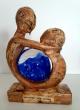Sculpture en bois avec inscrutation d'une boule de verre bleue 
La Sculpture est patiné 